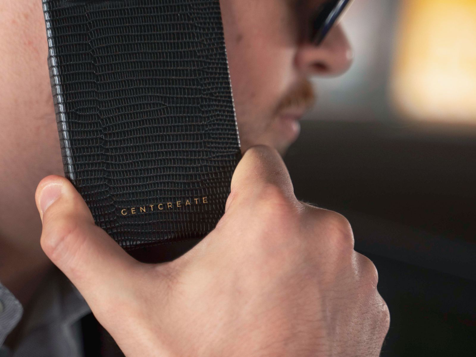 A man holding a phone in a textured black case