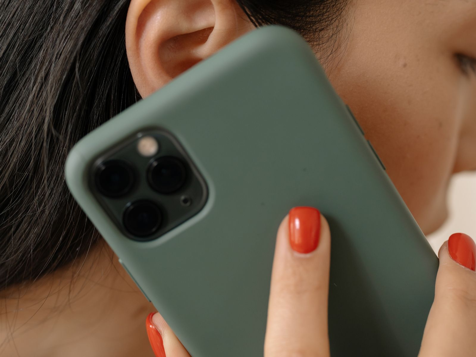 A woman holding a phone in a sage green case