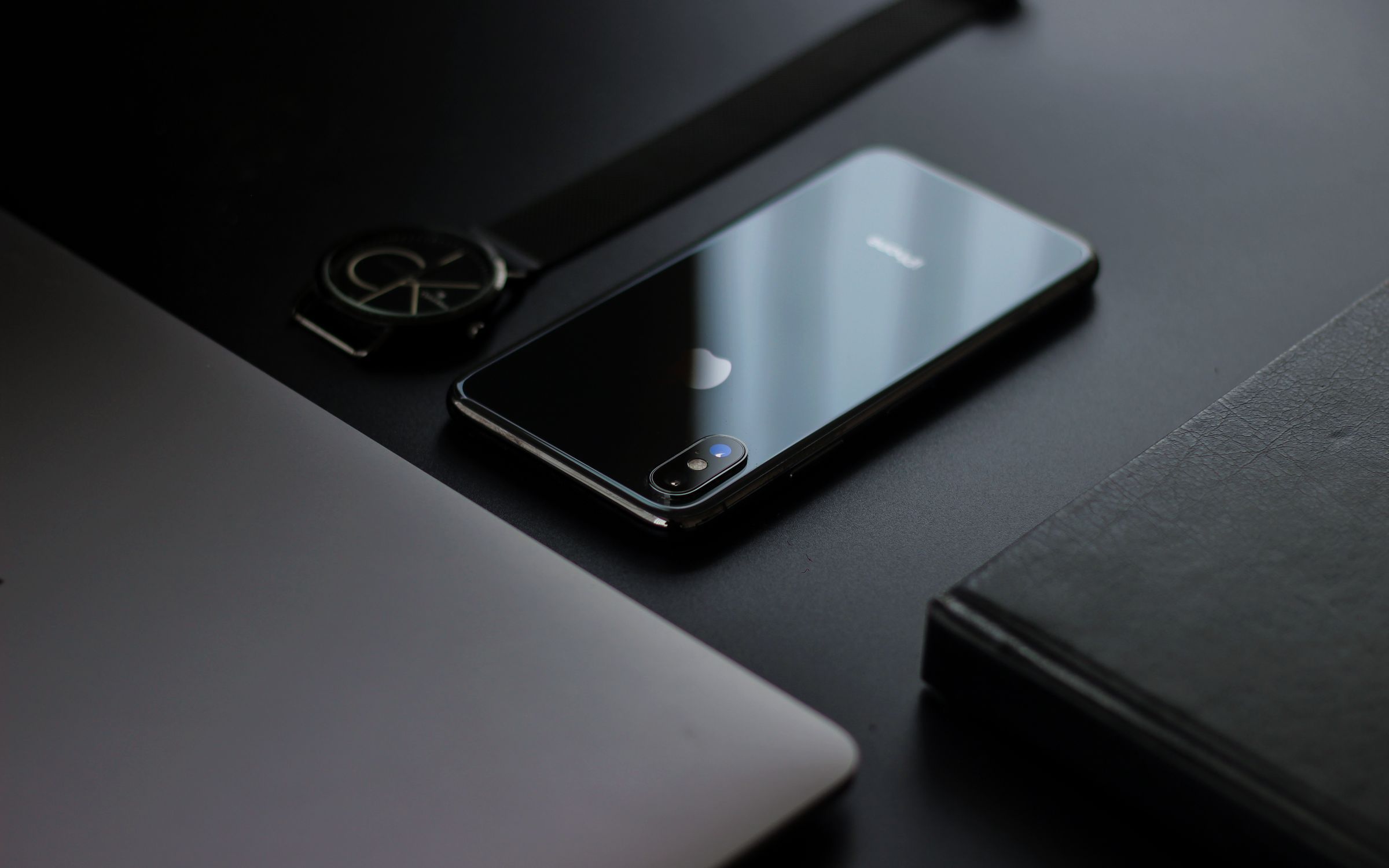 Two dark phones on a dark surface